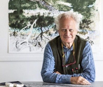 Photo of artist John Wolseley infront of one of his famous landscape paintings